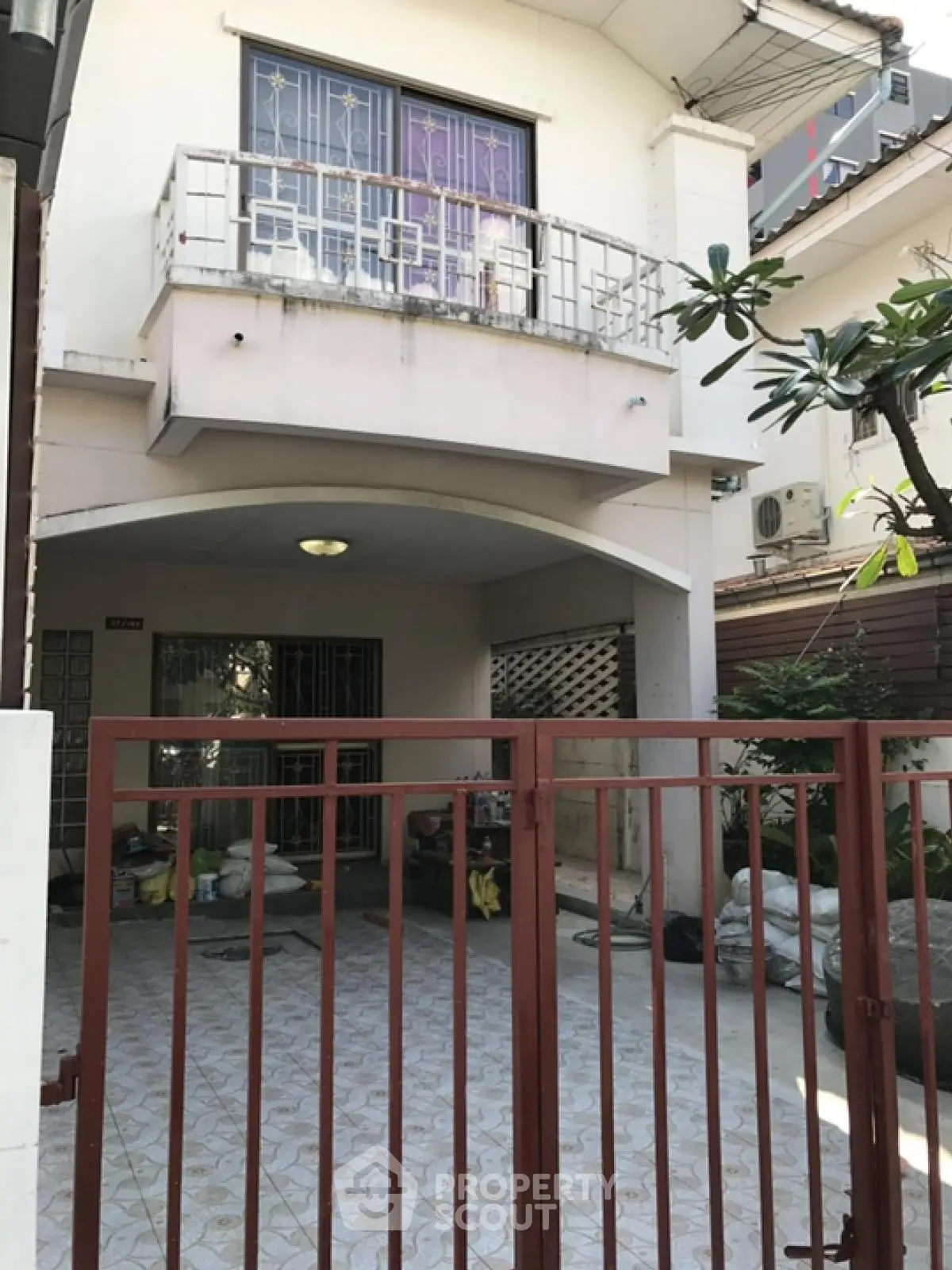Charming two-story house with gated entrance and balcony in a quiet neighborhood.