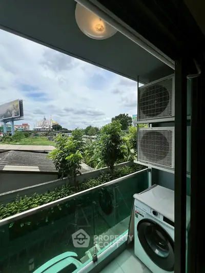 Charming balcony with lush greenery and city view, featuring modern washing machine.