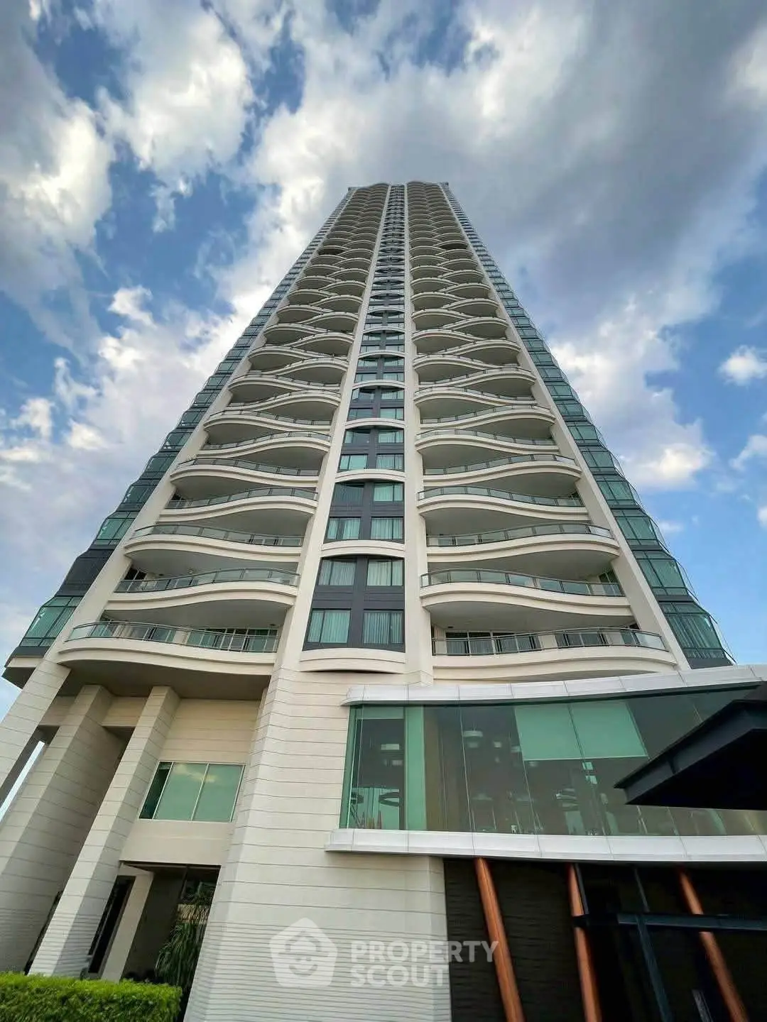 Stunning high-rise building with modern architecture and expansive glass windows against a blue sky.