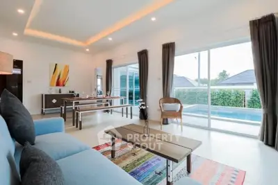 Spacious living room with pool view, modern decor, and ample natural light.