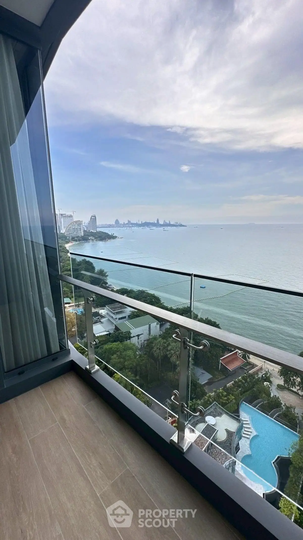 Stunning ocean view from a modern balcony with glass railing, perfect for relaxation.