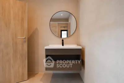 Modern minimalist bathroom with round mirror and sleek vanity
