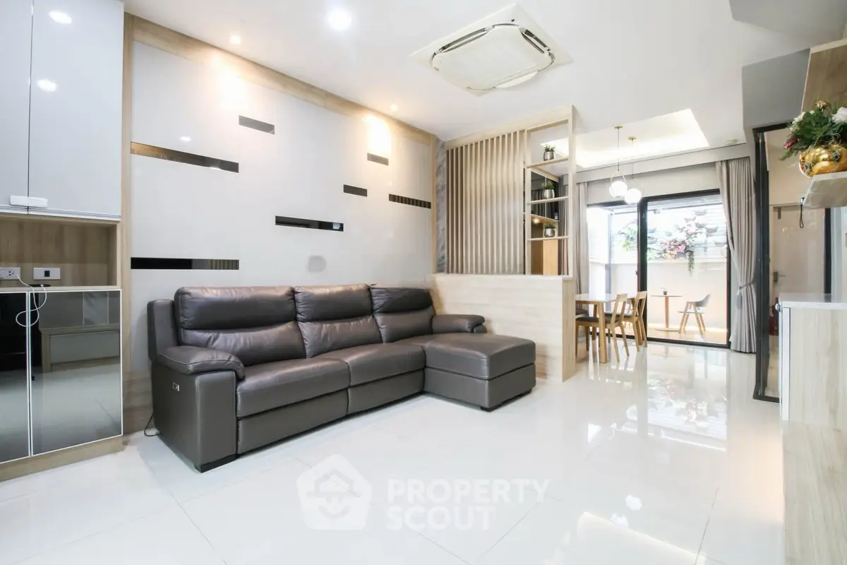 Modern living room with sleek design and open layout, featuring a comfortable leather sofa and stylish decor.
