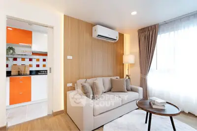 Modern living room with cozy sofa, air conditioning, and view into stylish kitchen.