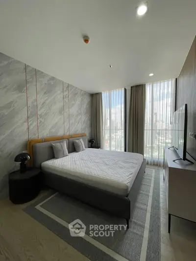 Modern bedroom with large windows and stylish decor in high-rise apartment.
