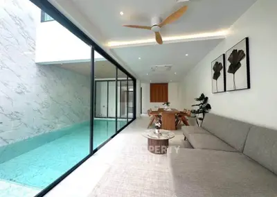 Luxurious modern living room with pool view, elegant decor, and spacious seating area.