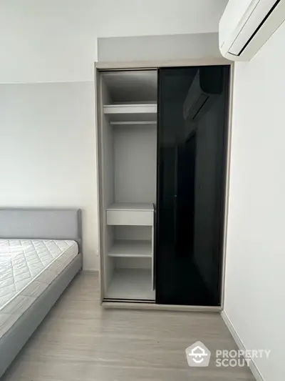 Modern bedroom with sleek wardrobe and air conditioning unit