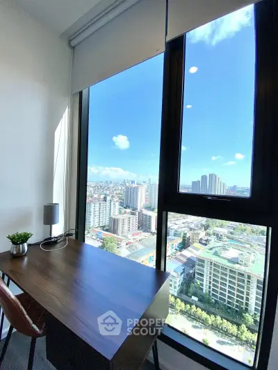 Stunning city view from modern study room with large window and sleek desk.