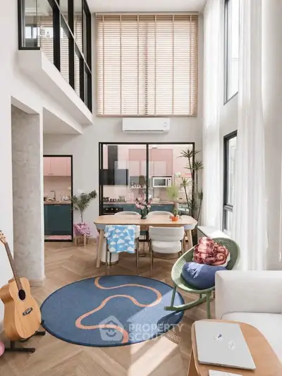 Modern living room with high ceilings, stylish decor, and abundant natural light.