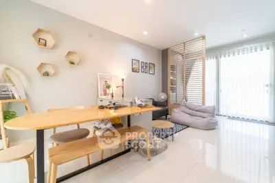 Modern living room with stylish decor and natural light, featuring a cozy seating area and wooden dining table.