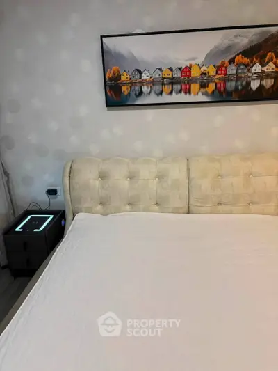 Cozy bedroom with elegant decor and modern nightstand in a stylish apartment.