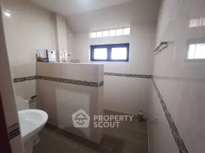 Spacious bathroom with modern tiling and natural light
