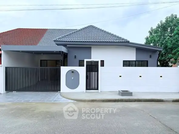 Modern single-story house with stylish roof and gated entrance in a serene neighborhood.