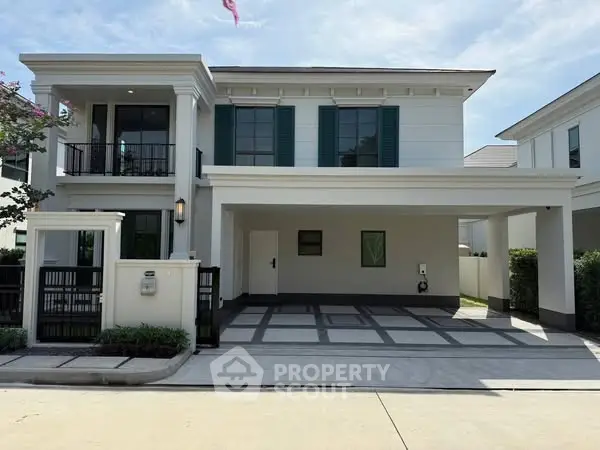 Elegant modern two-story house with spacious driveway and balcony in a serene neighborhood.