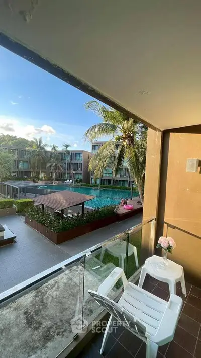 Stunning balcony view overlooking a luxurious pool and lush palm trees in a modern residential complex.