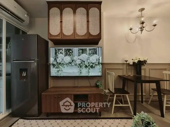 Charming living room with modern decor, featuring a sleek fridge, elegant chandelier, and stylish dining area.