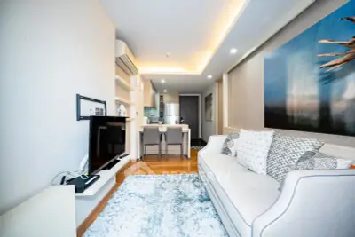 Modern living room with stylish decor and open kitchen layout, featuring cozy seating and elegant lighting.