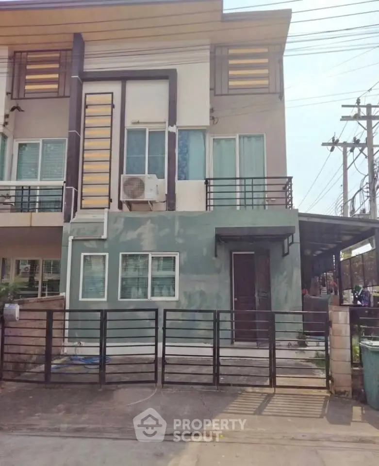 Modern two-story townhouse with gated entrance and balcony