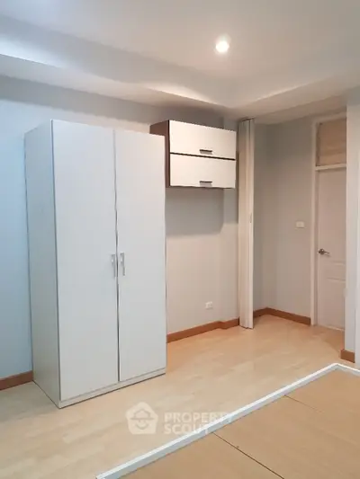 Modern minimalist bedroom with sleek wardrobe and light wood flooring
