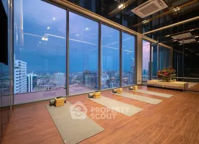 Luxurious high-rise gym with panoramic city views and yoga mats, perfect for fitness enthusiasts.