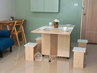 Modern dining area with compact wooden table and stools in cozy apartment setting.