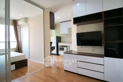 Modern studio apartment with open layout, featuring sleek furniture and a compact kitchen area.