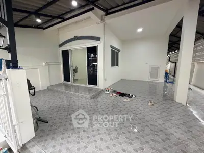 Spacious tiled patio with sliding glass doors and modern roof, perfect for outdoor relaxation.