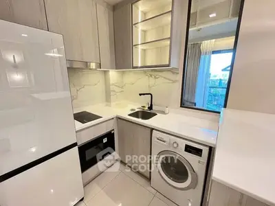 Modern kitchen with sleek appliances, washing machine, and elegant cabinetry in a stylish apartment.
