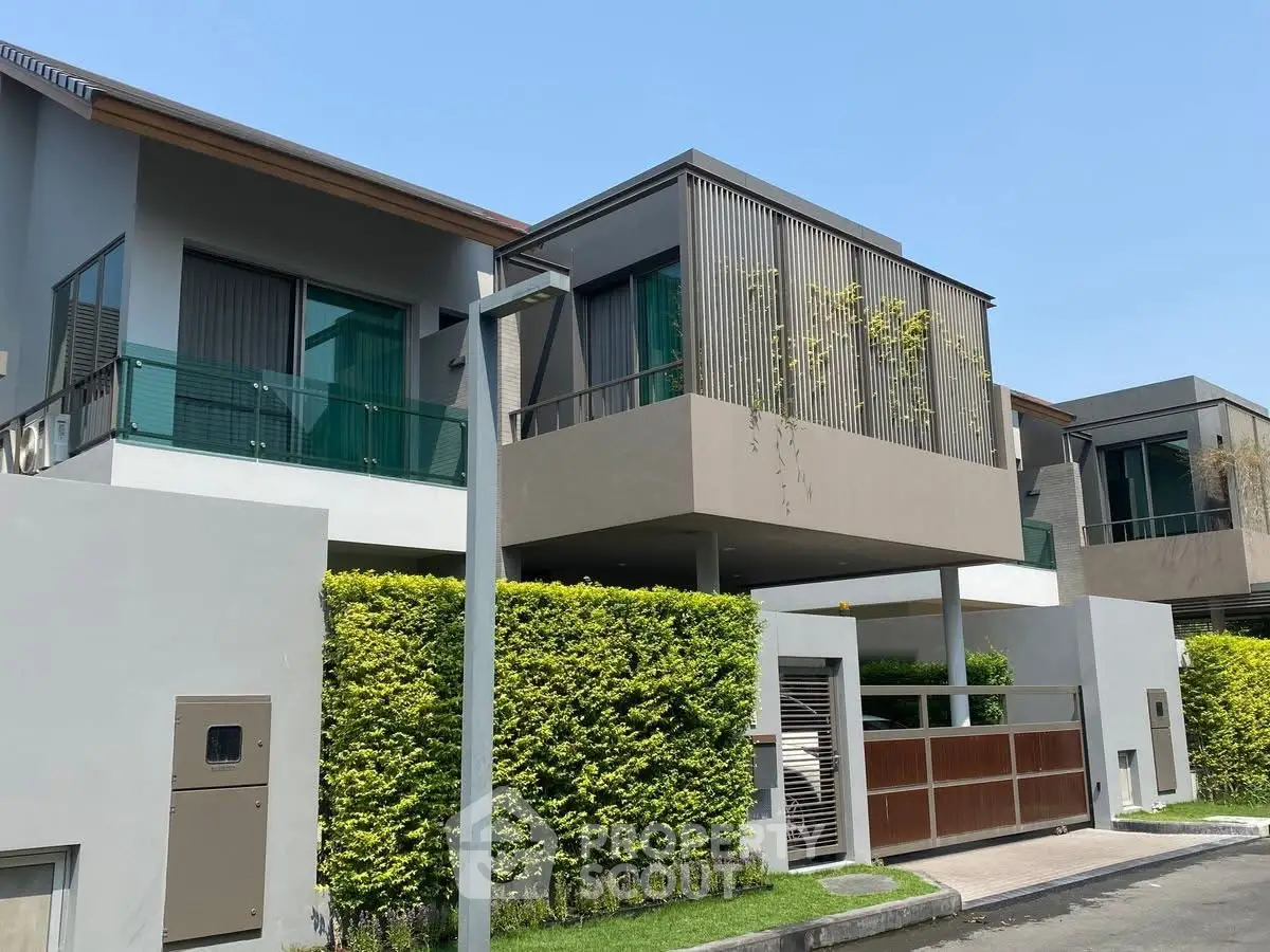 Modern townhouse exterior with lush greenery and sleek architectural design.