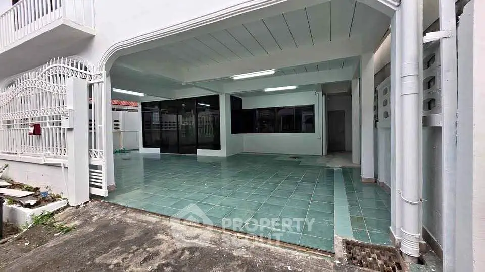 Spacious open garage area with tiled flooring and modern design, perfect for multiple vehicles or versatile use.