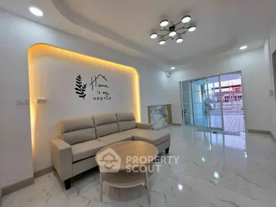 Modern living room with stylish lighting and cozy sofa, featuring a wall art saying 'Home is my castle'.