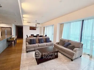 Spacious modern living room with elegant furniture and open kitchen layout.