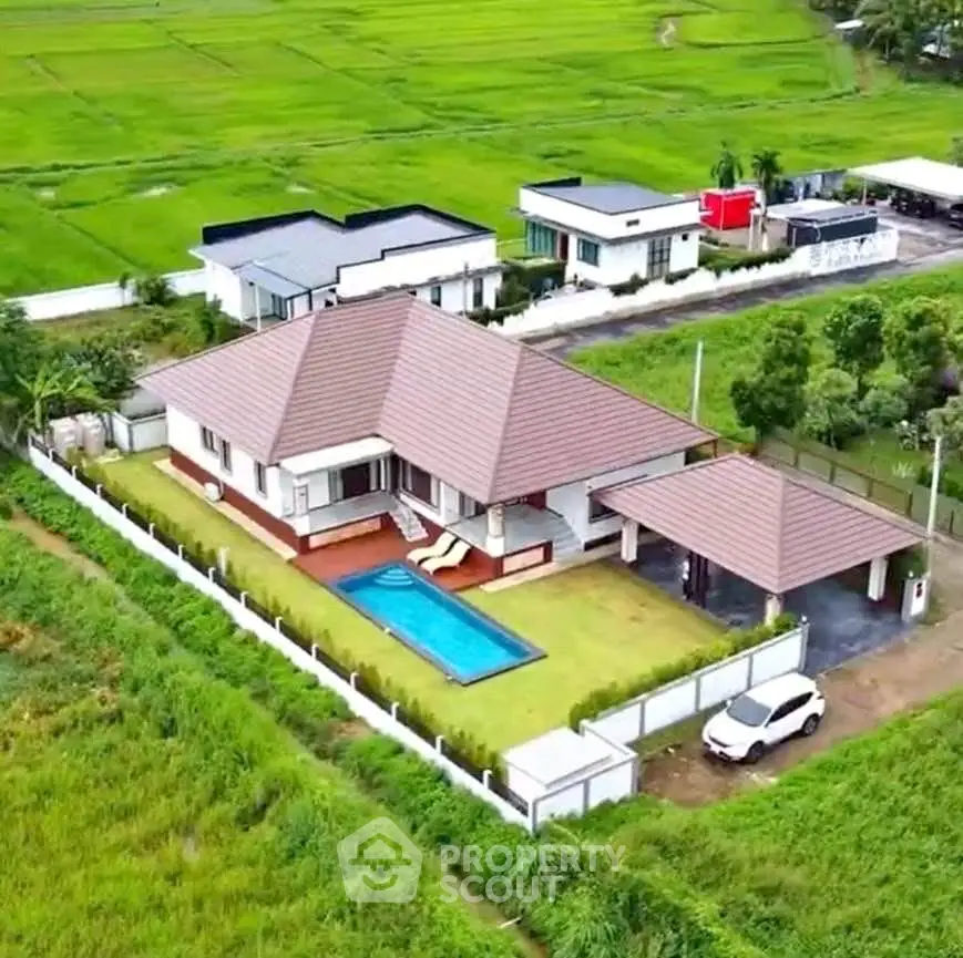 Stunning aerial view of modern villa with private pool and lush green surroundings.