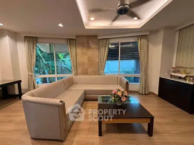 Elegant living room with modern L-shaped sofa and large windows offering natural light.
