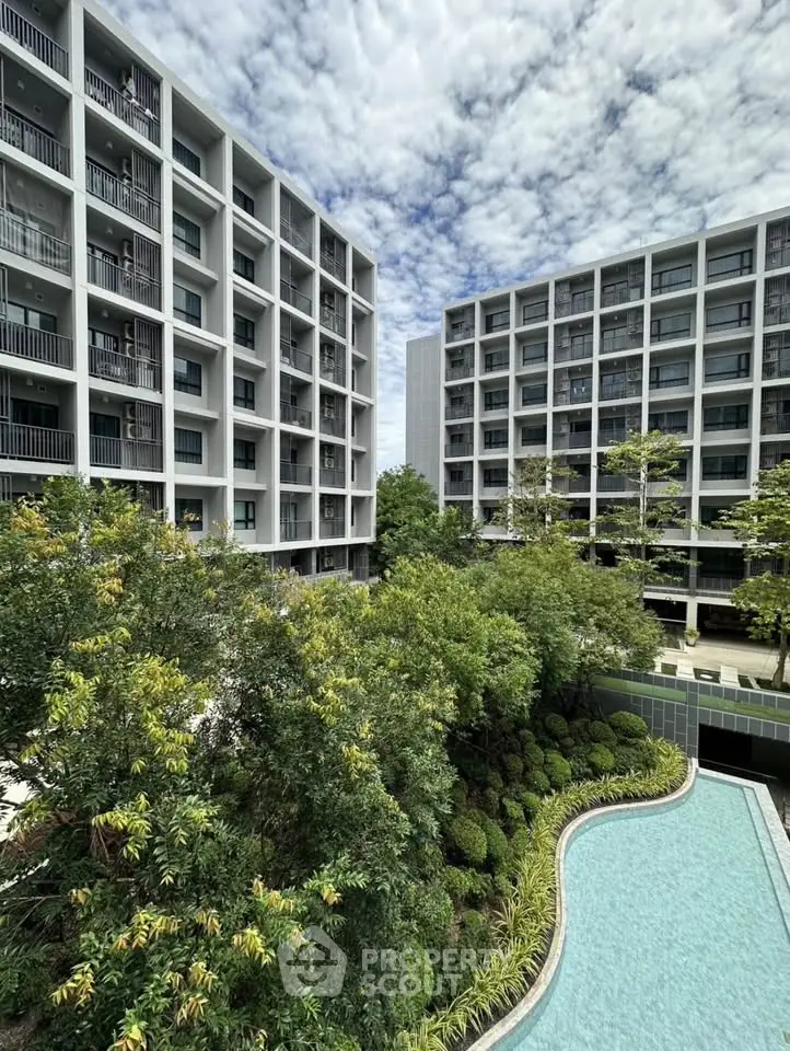 Modern apartment complex with lush garden and pool view