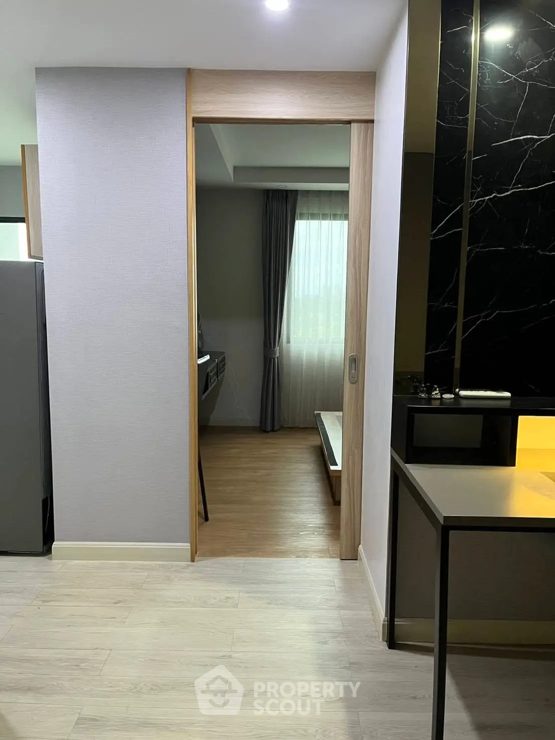 Modern apartment interior with sliding door and sleek kitchen design