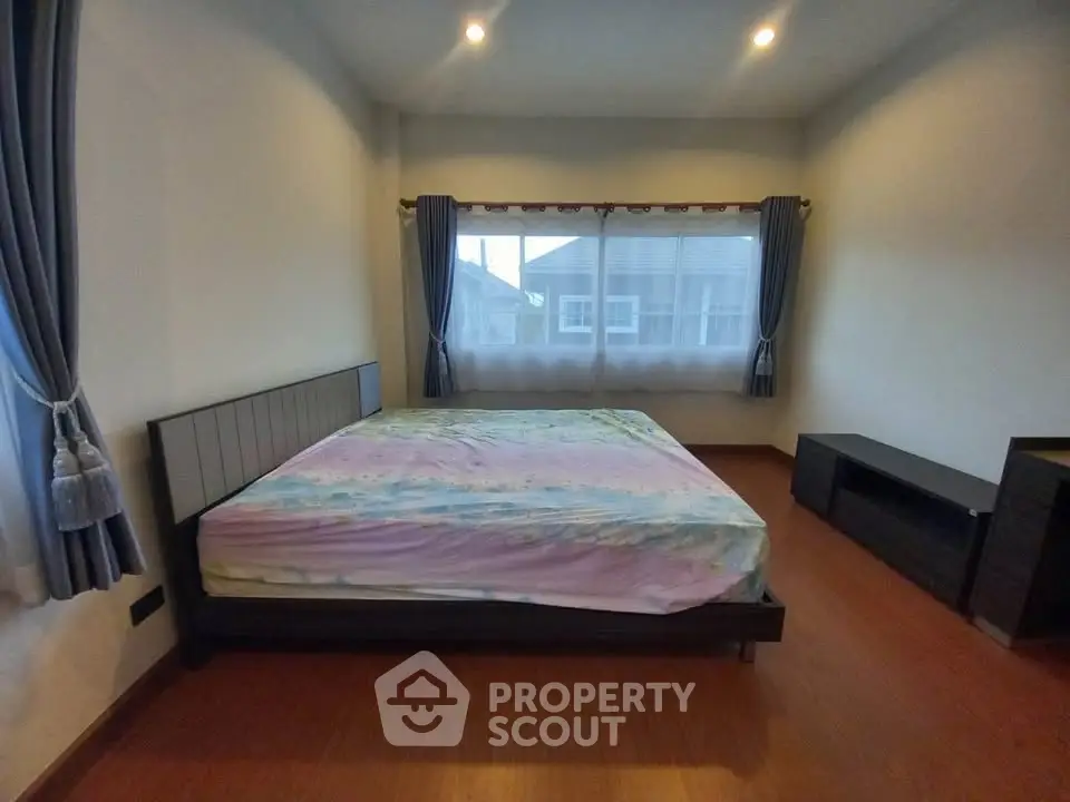 Spacious bedroom with large windows and modern furnishings