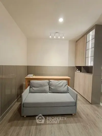 Modern living room with stylish sofa and wooden accents, perfect for cozy relaxation.