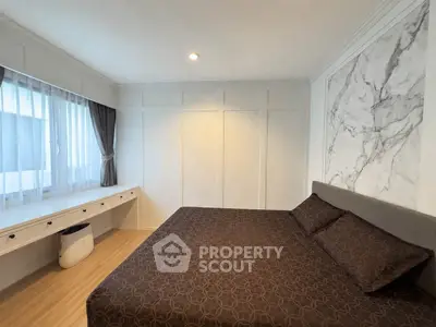Spacious bedroom with elegant decor and large window for natural light