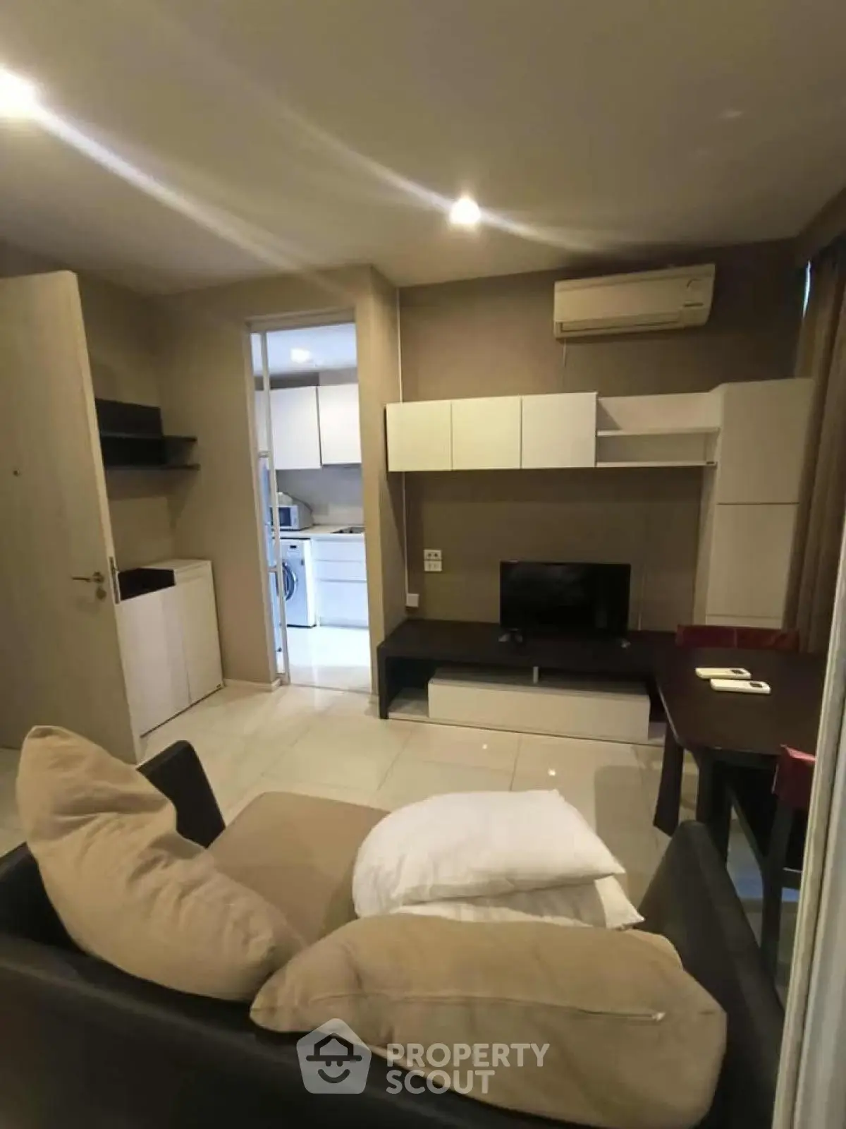 Cozy living room with modern furniture and open view to kitchen area, perfect for urban living.