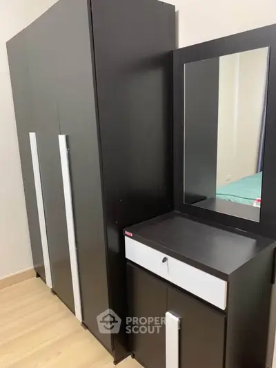 Modern bedroom with sleek black wardrobe and matching dresser with mirror