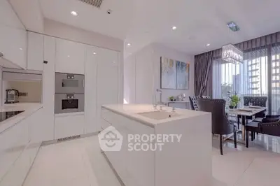 Luxurious modern kitchen with sleek white cabinetry and elegant dining area