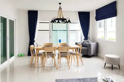 Modern dining area with elegant chandelier and natural light in a stylish home interior.
