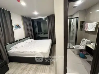 Modern bedroom with ensuite bathroom featuring sleek design and large windows for natural light.