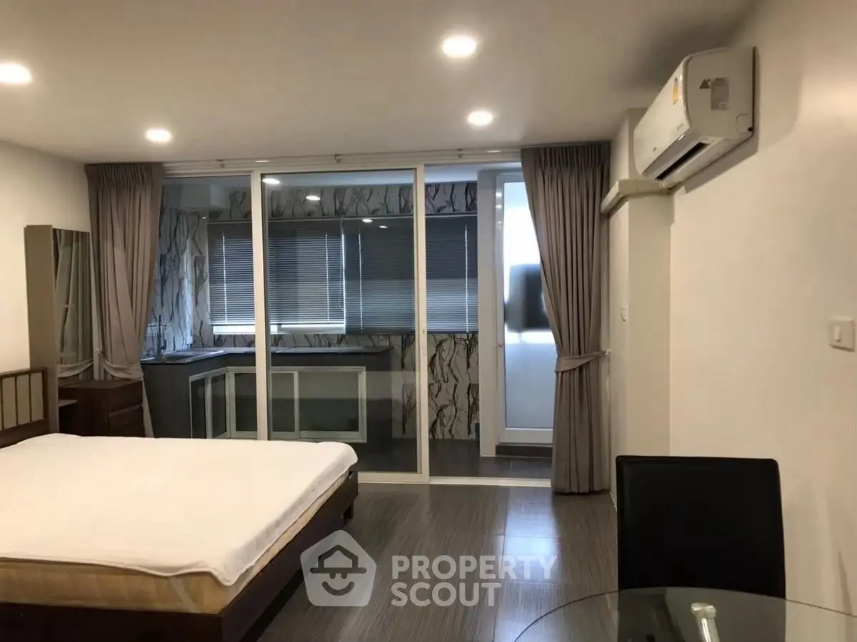 Spacious bedroom with modern decor and large windows for natural light
