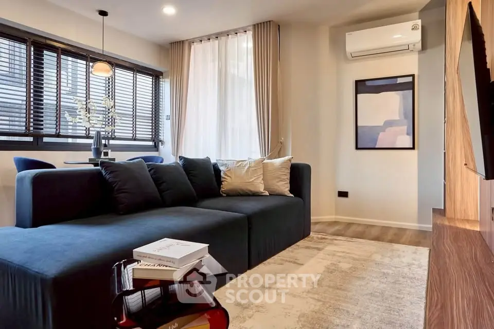 Modern living room with stylish sofa and air conditioning, featuring elegant decor and natural light.