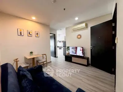 Modern living room with cozy seating, stylish decor, and open kitchen layout in a contemporary apartment.