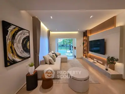 Modern living room with stylish decor and large TV, featuring a cozy seating area and elegant lighting.