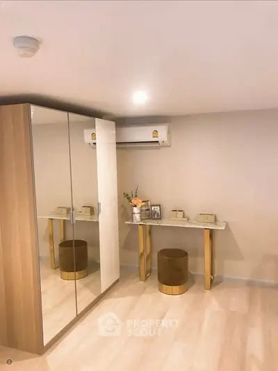 Modern bedroom with mirrored wardrobe and air conditioning unit