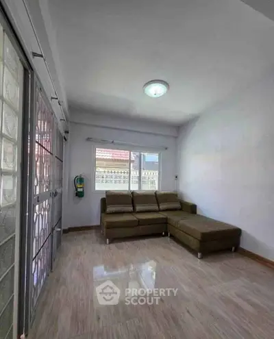 Spacious living room with modern sectional sofa and large window for natural light.